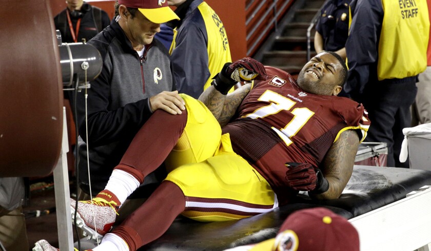 Washington Redskins tackle Trent Williams (71) is treated along the sidelines after a right knee injury during the second half of the game against the New York Giants on Thursday night.