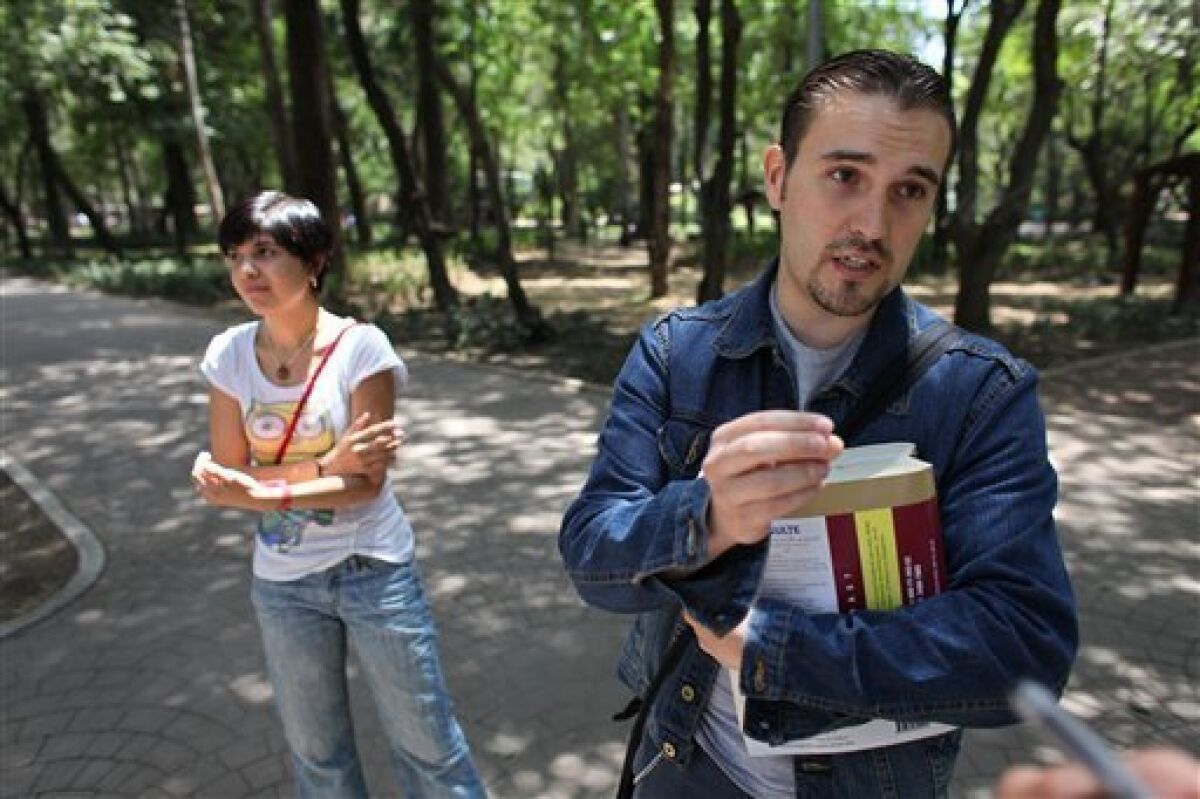In this photo taken May 5, 2009, Dr. Julian Sosa, right, who was recently treated for the H1N1, or swine flu, influenza virus, stands with his girlfriend Dr. Cynthia Rojas, during an interview with The Associated Press at a park, in Mexico City. (AP Photo/Brennan Linsley)