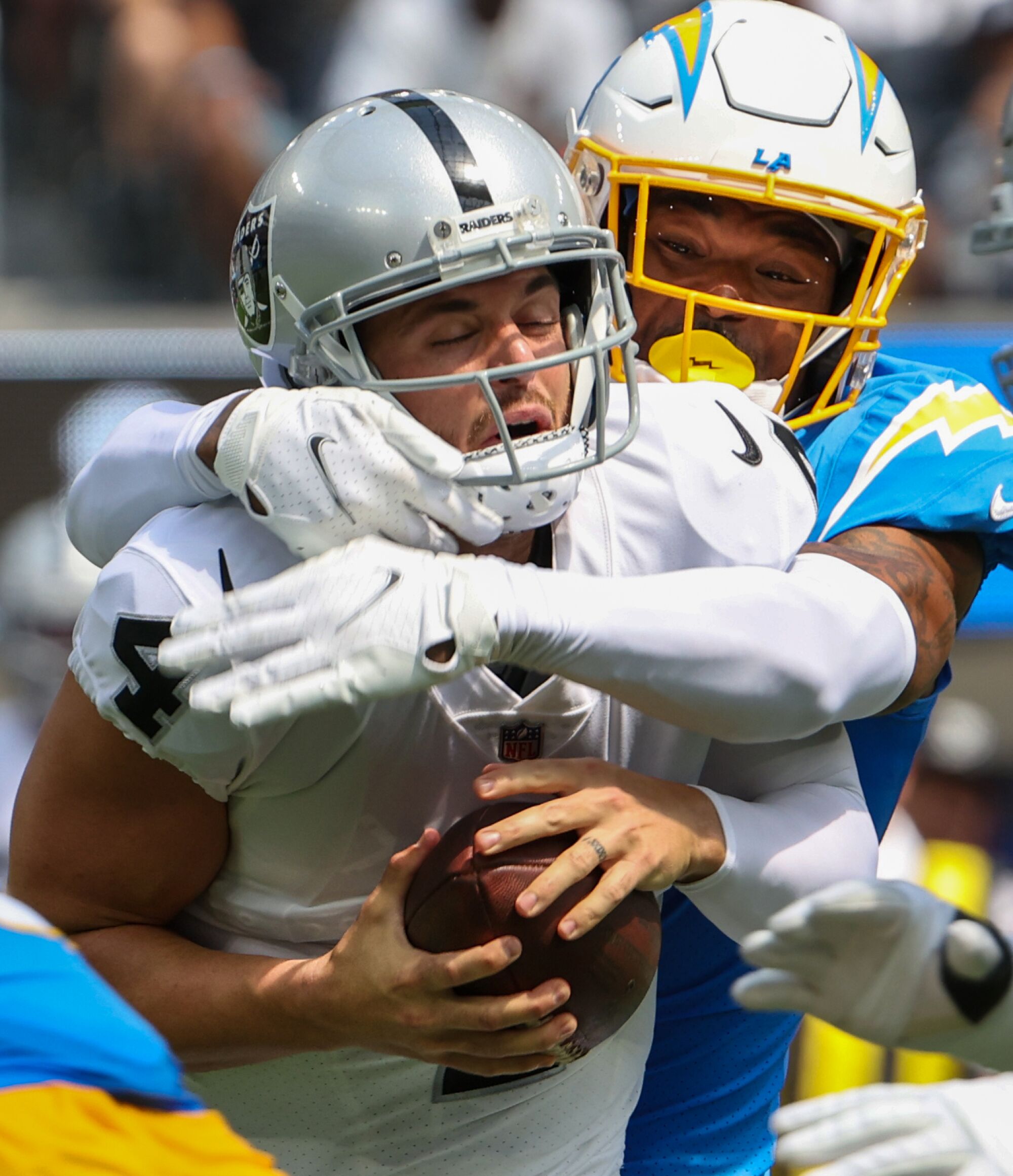 Raiders quarterback Derek Carr is sacked by Chargers safety Derwin James Jr.