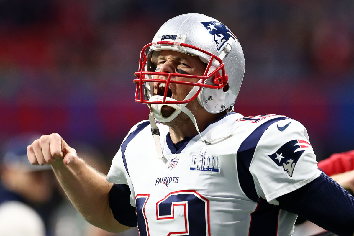 ATLANTA, GEORGIA - FEBRUARY 03: Tom Brady #12 of the New England Patriots pumps his fist running onto the field.
