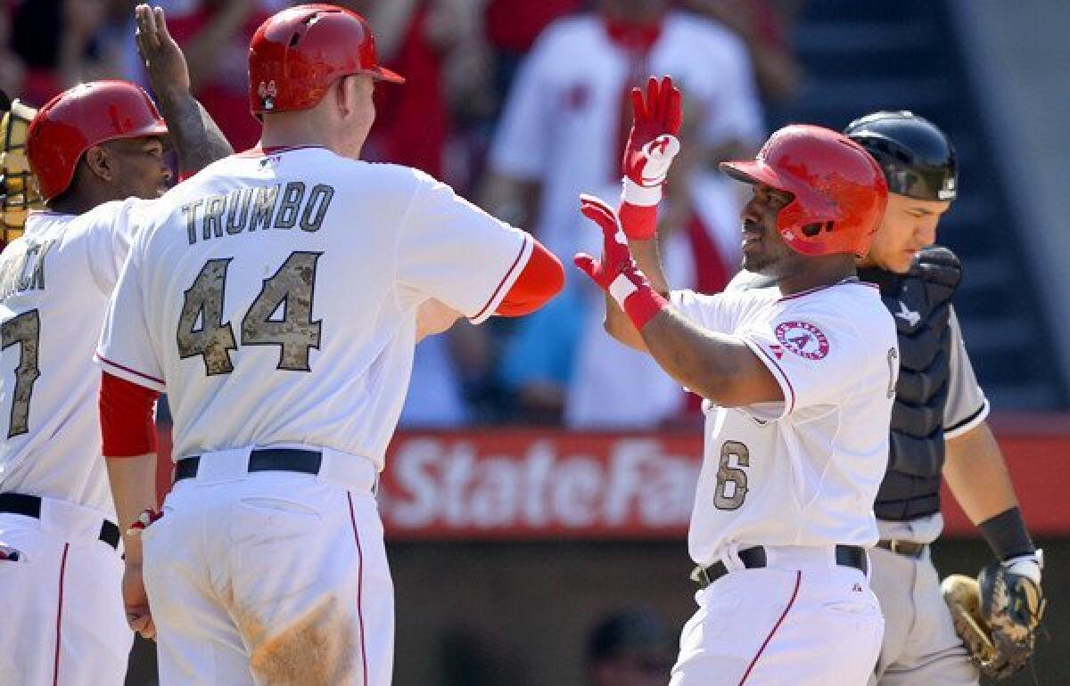 Angels third baseman Alberto Callaspo (6) is congratulated by teammates Mark Trumbo and Howie Kendrick after hitting a three-run home run in the seventh inning against the Chicago White Sox on Saturday.