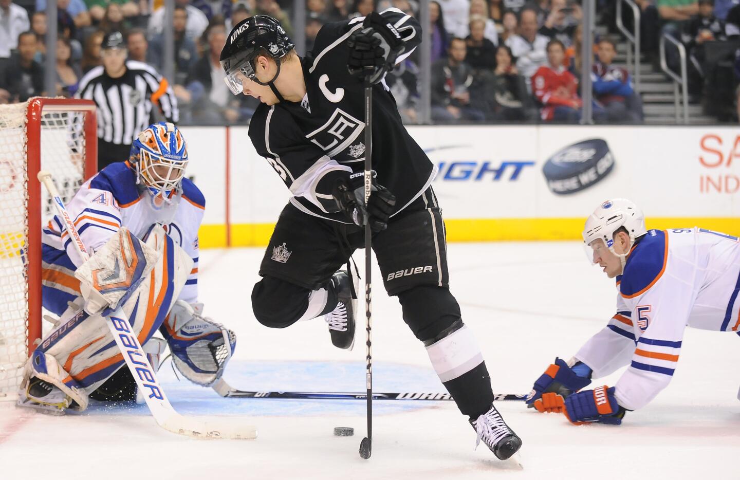 Kings' Dustin Brown takes a shot on Oilers goalie Devan Dubnyk as Ladislav Smid helps on defense in the first period.