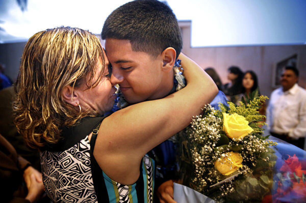 Marlene Chapa hugs her son Robert Placensia at the Cathedral of Our Lady of Angels after his Verbum Dei High School graduation ceremony on June 6, 2013.