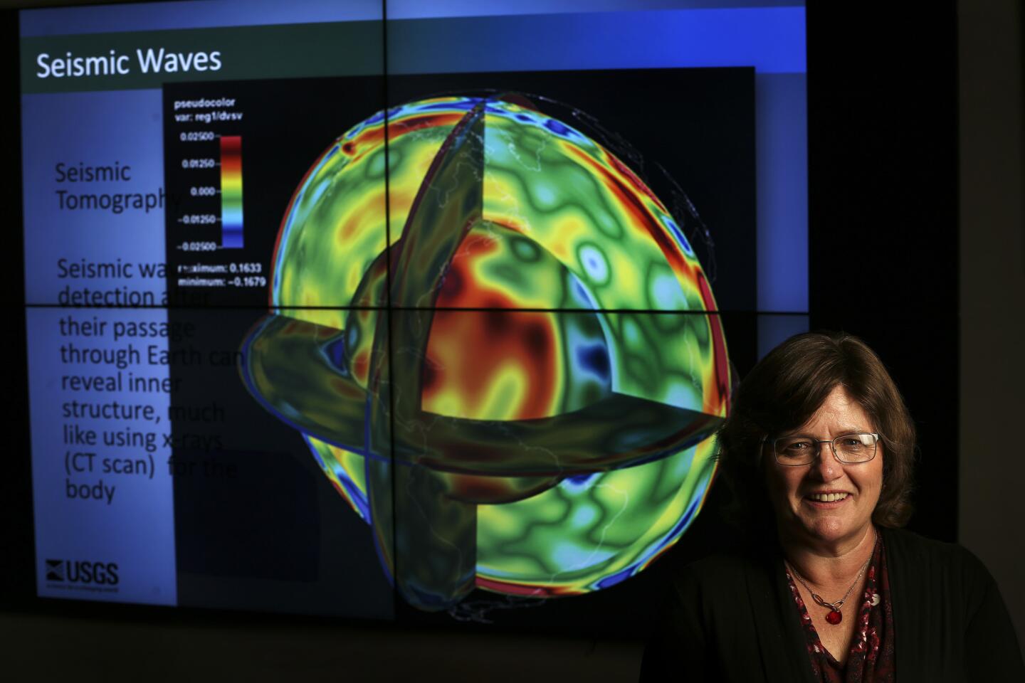 Lucy Jones standsnext to a projected image of seismic waves inside the media room at Caltech. Much of what Jones does today centers on this: What good is scientific knowledge if people don’t use it?