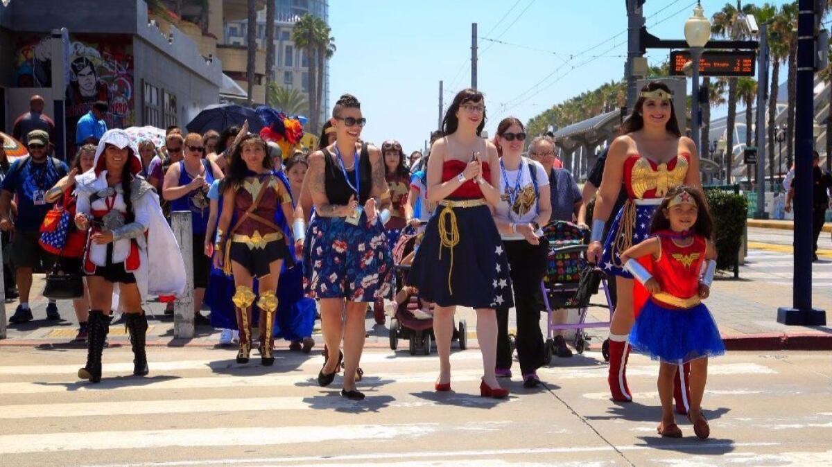 Convention attendees participate in a Wonder Woman parade around the Gaslamp Quarter during Comic-Con 2017 in San Diego.
