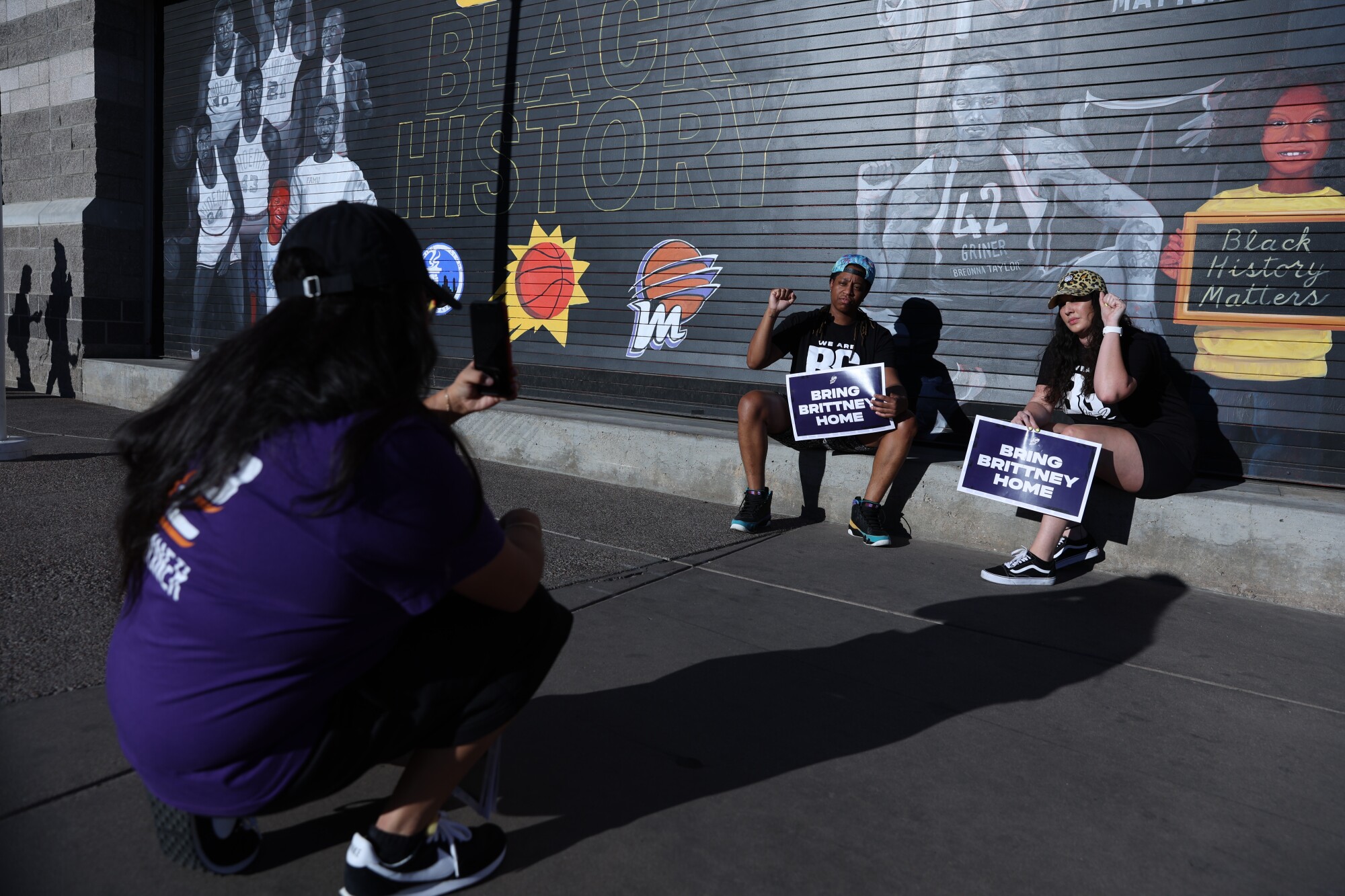 Supporters pose with a mural depicting Britney Griner following a rally 