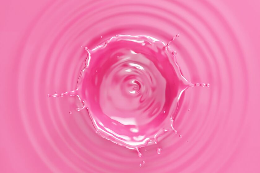 Pink liquid with ripples and crown splash viewed from top.