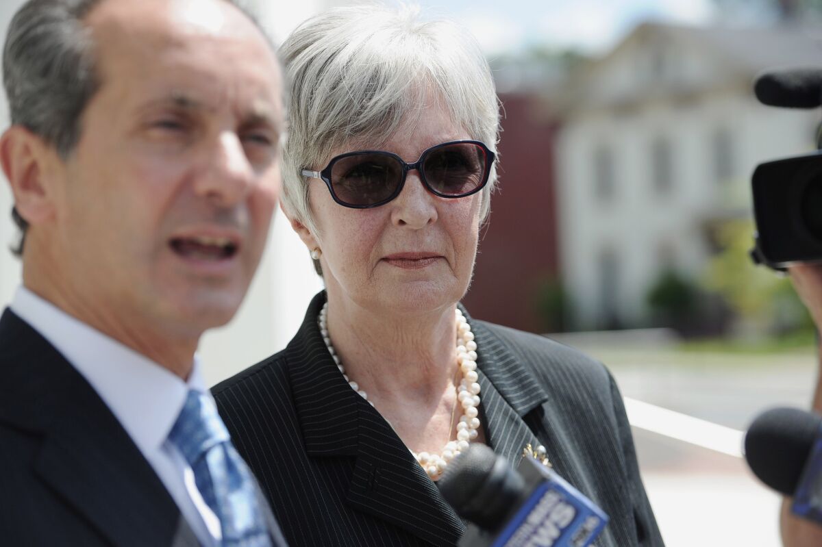 Tamara Green, right, listens as her attorney Joseph Cammarata speaks to the media after a hearing at U.S. District Court in Springfield, Mass., in June 2015. Green is one of three women who have filed a defamation lawsuit against Bill Cosby.