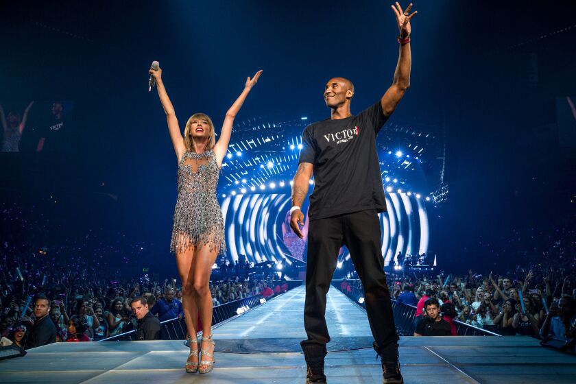 Taylor Swift welcomes Kobe Bryant to the stage during the opening night of her five concerts at Staples Center.