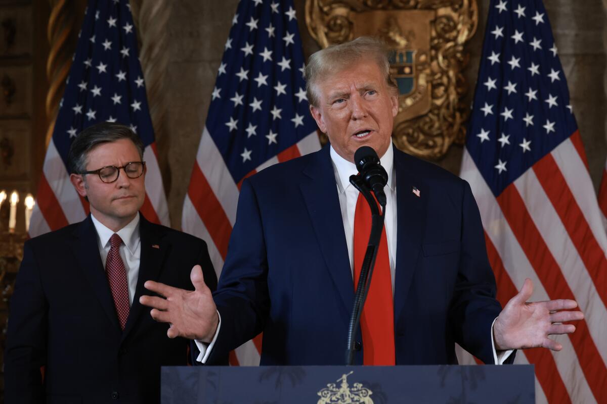 Mike Johnson and Donald Trump at a lectern