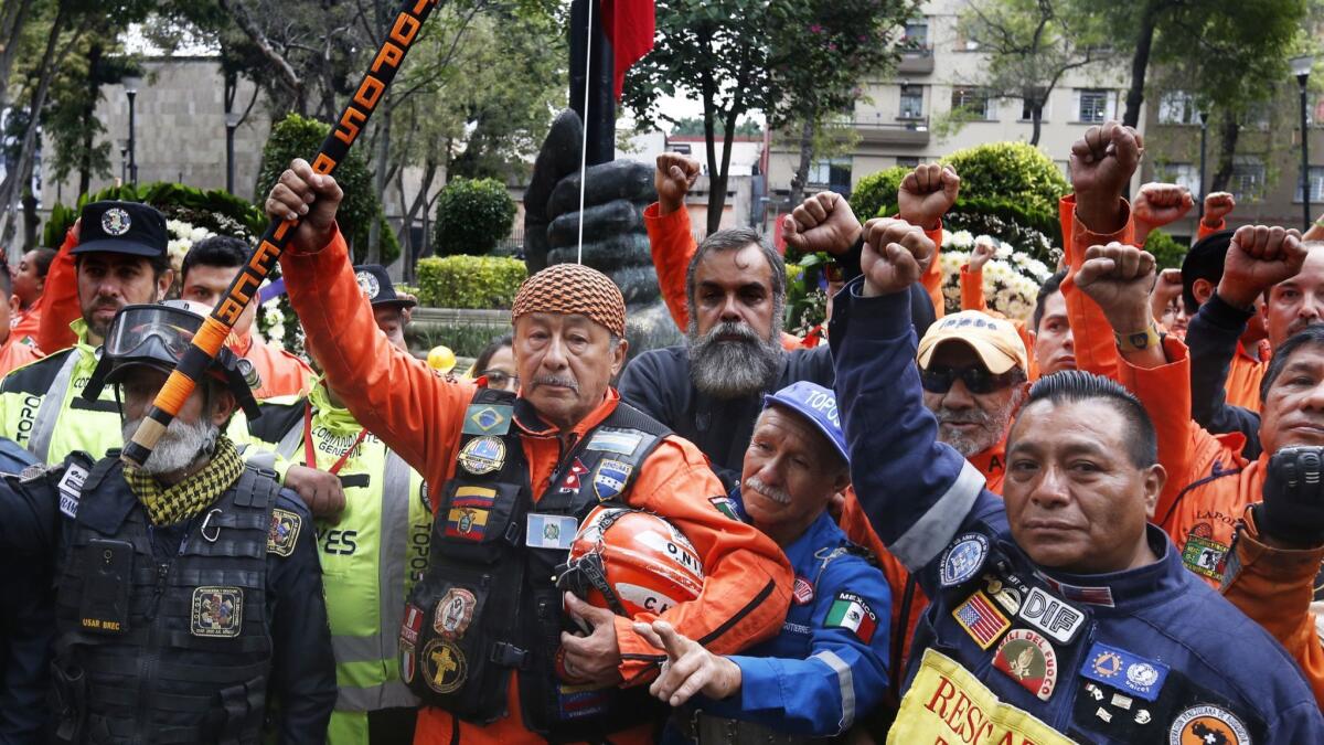 Rescue workers stand in silence in front of a 1985 earthquake memorial in Mexico City during a ceremony marking that quake's 33rd anniversary and last year's magnitude 7.1 earthquake.