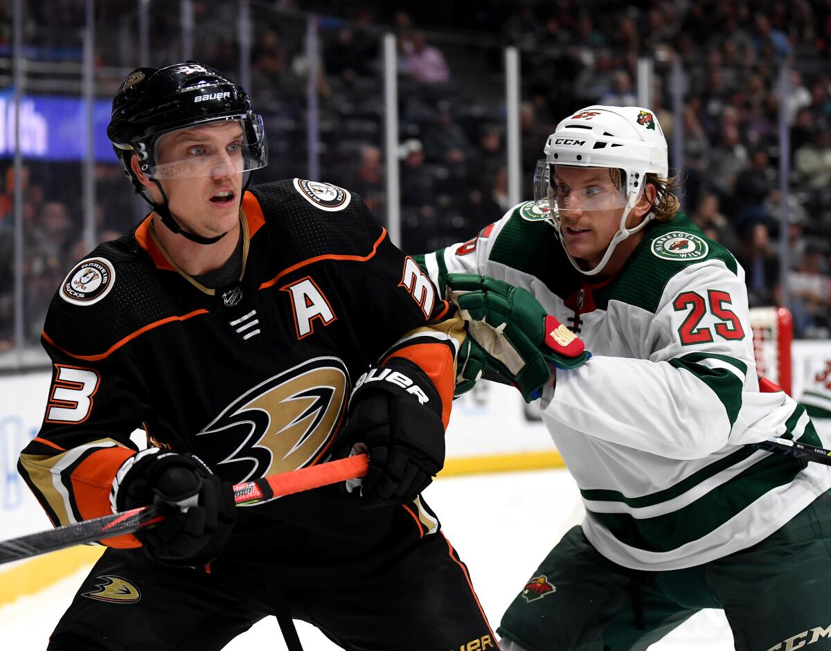 The Ducks' Jakob Silfverberg, left, is pushed by the Wild's Jonas Brodin during the first period at Honda Center on Tuesday.