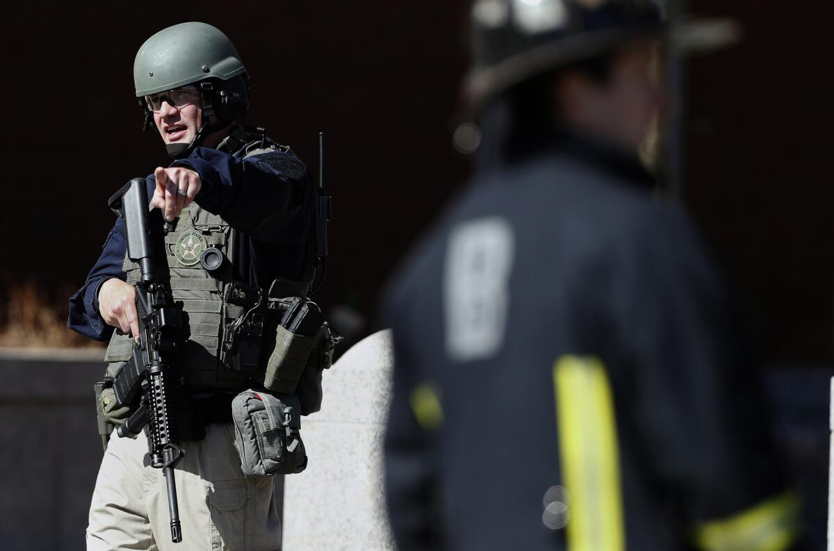 A heavily armed member of the U.S. Marshals Service stands guard outside the Moakley Federal Court House in Boston after the building was evacuated on Wednesday.