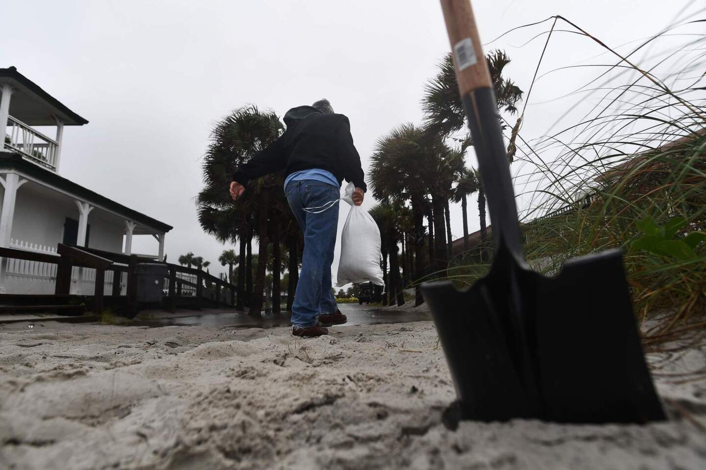 A local resident collects sand in a bag from the Neptune beach to use for flood protection at his house ahead of hurricane Matthew in Jacksonville, Florida on Oct. 6, 2016.