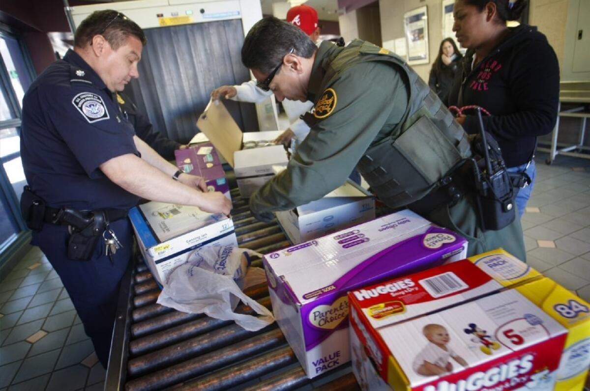 Customs agents at work in this file photo from four years ago. Border and immigration agents have recently detained U.S. citizens, a Holocaust historian and a baby-book author and, in one case, sought papers from passengers aboard a domestic flight. Welcome to the new America.