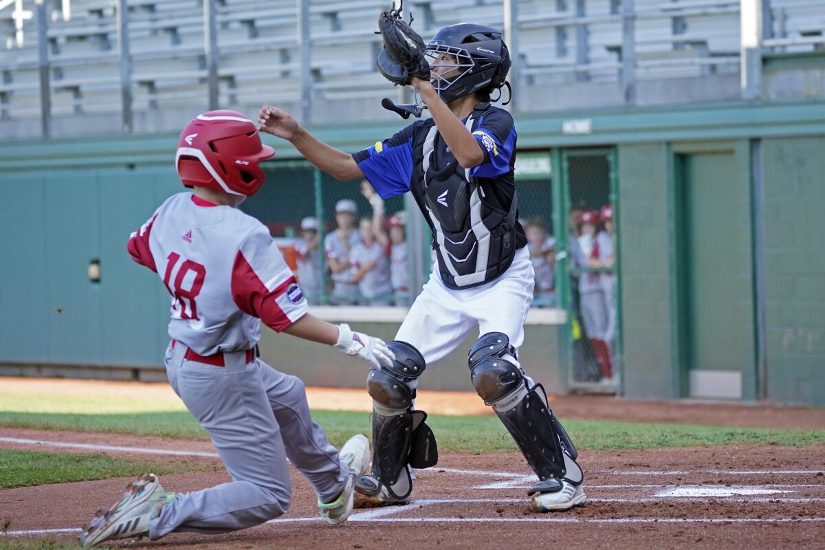 Sioux Falls, S.D.'s Boston Bryant slides on the way to scoring in front of Torrance, Calif., catcher Andrew Nuruki 