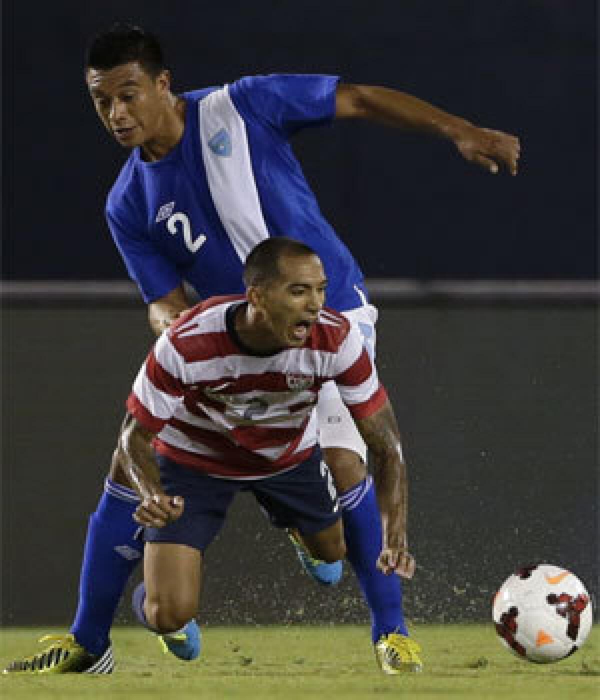 Edgar Castillo of the U.S. team, front, falls as Guatemala's Carlos Castrillo defends during an international friendly soccer match in July.