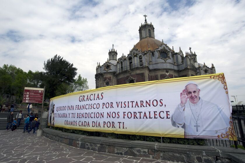 A banner for Pope Francis hangs near the Basilica of Our Lady of Guadalupe in Mexico City. Although many Mexicans eagerly await the pontiff's arrival Friday, some are asking whether money spent on the trip would be better spent on poverty, education and other issues.