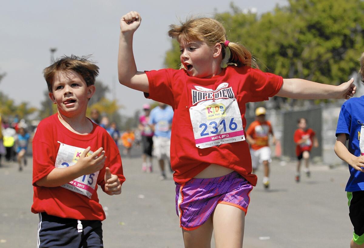 Brayden and Hanna Wood cross the finish line during the 2013 Kids Run the OC at the Orange County fairgrounds in Costa Mesa. This year's race is Saturday.