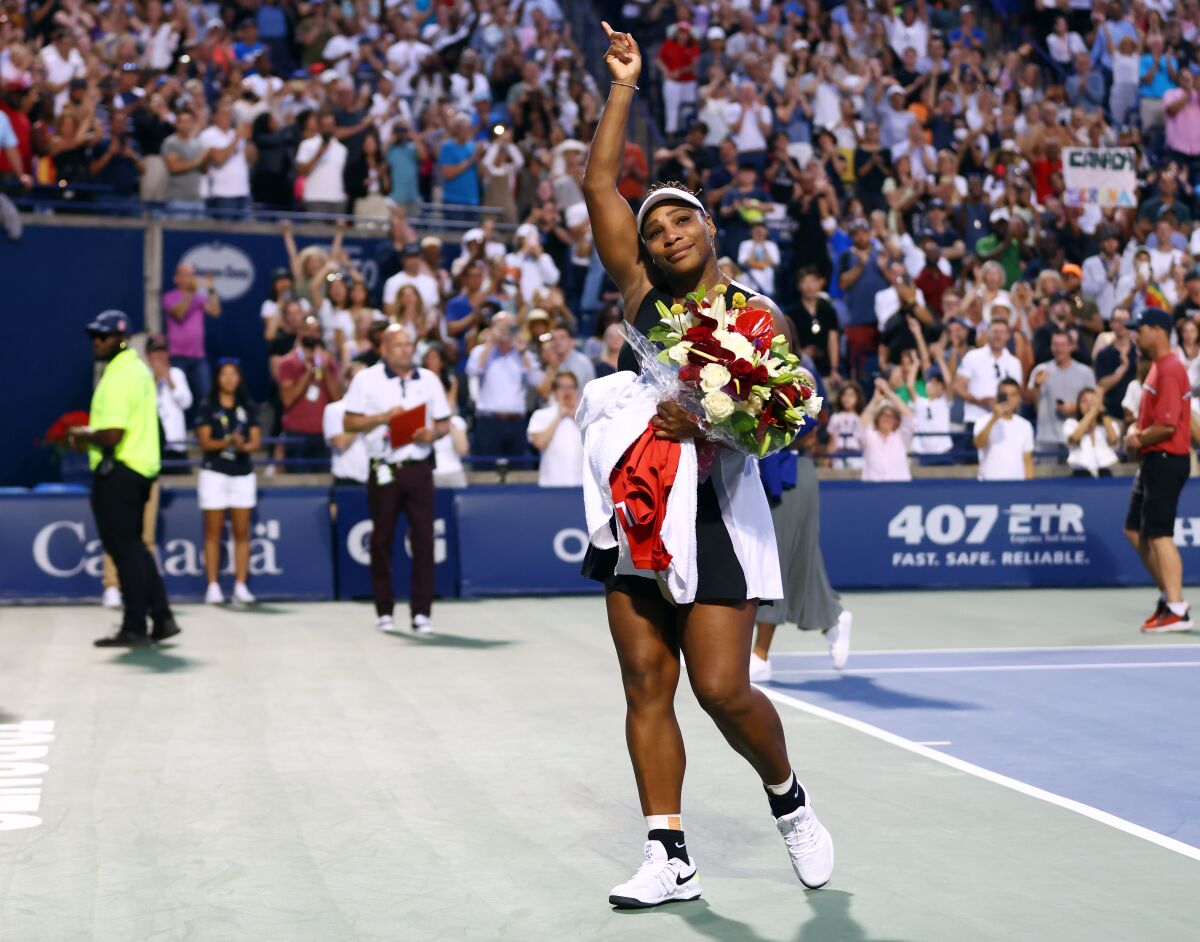 Serena Williams waves to the crowd as she leaves the court.