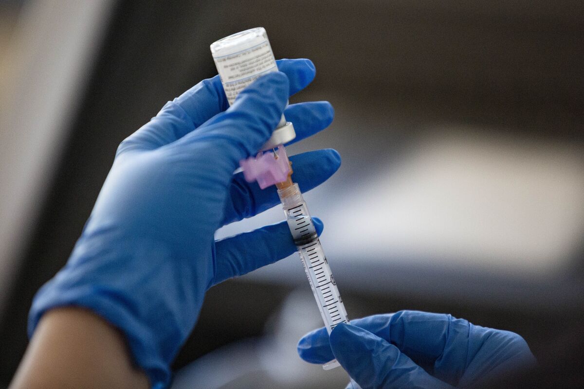  A vaccine being extracted from a bottle 