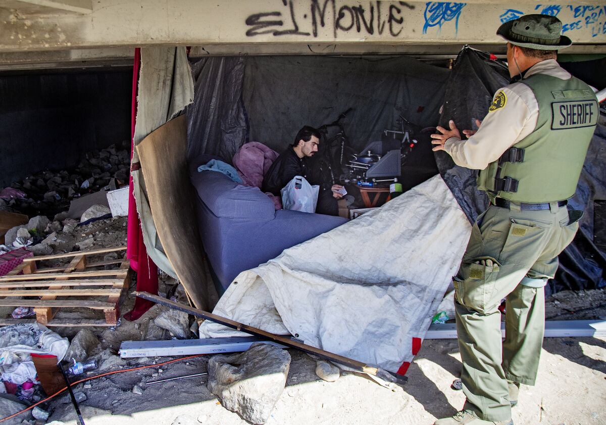 A sheriff's deputy visits a homeless emcampment 