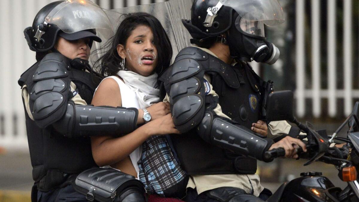 An anti-government activist is arrested and taken away by national police during a protest against Venezuelan President Nicolas Maduro in 2014