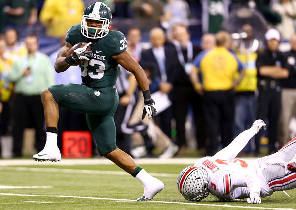 Michigan State running back Jeremy Langford evades Ohio State defensive back Corey Brown to score the game-winning touchdown in the Big Ten Conference championship game.