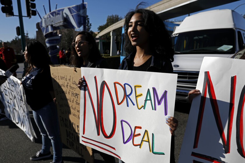 Emily Hebbard, center, and her daughter Maxine Hebbard, right, call for protections for young immigrants here illegally during a protest at Disneyland.