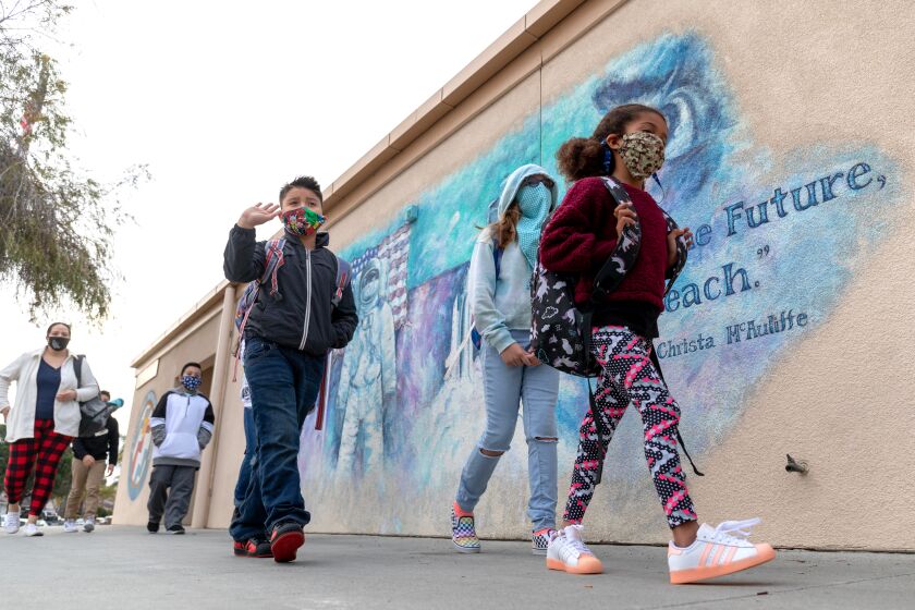 Students of McAuliffe Elementary School make their way to class after arriving on campus on Monday. Oceanside Unified reopened itOs elementary schools on Monday. N photo by Don Boomer
