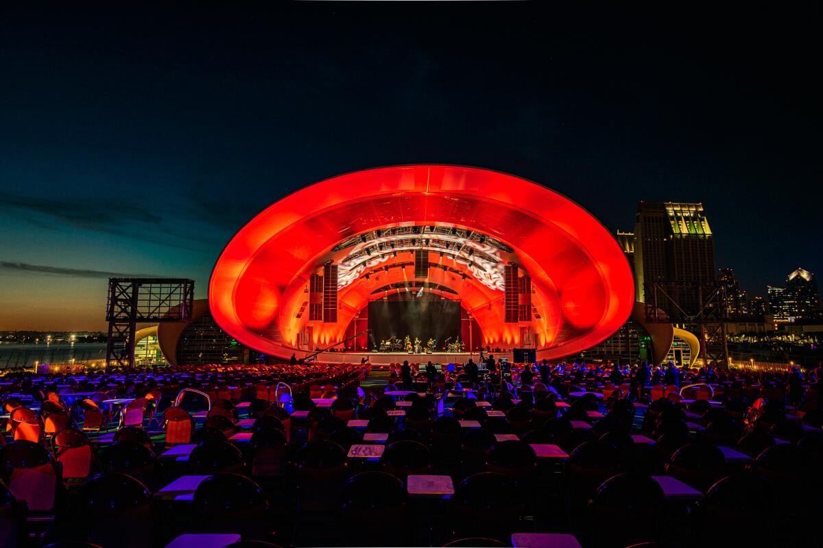 A nighttime view of the Rady Shell crowned in red light.