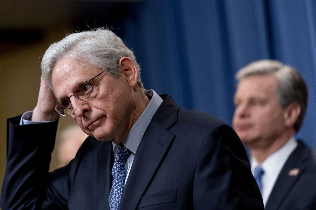 Attorney General Merrick Garland, accompanied by FBI Director Christopher Wray, right, takes a question from a reporter during a news conference at the Justice Department in Washington, Wednesday, April 6, 2022, to discuss new and recent enforcement actions to disrupt and prosecute criminal Russian activity. (AP Photo/Andrew Harnik)