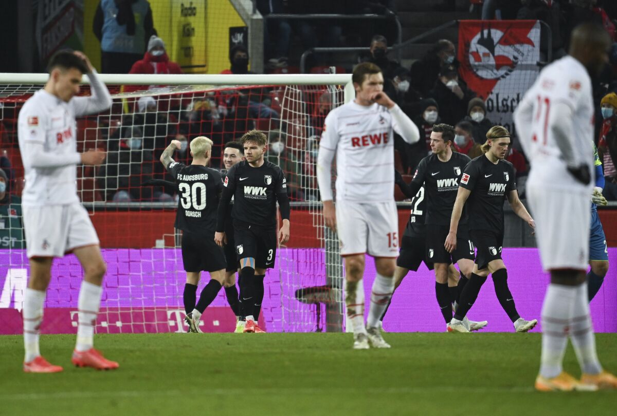 Augsburg's players celebrate scoring the first goal of the game during the German Bundesliga soccer match between 1. FC Cologne and FC Augsburg at the RheinEnergieStadion in Cologne, Germany, Friday, Dec. 10, 2021. (Federico Gambarini/dpa via AP)