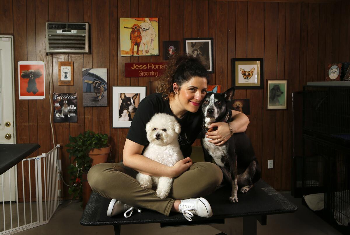 La estilista canina Jess Rona con sus dos perros, Meemu, izquierda, y Chupie, en su estudio en Los Ángeles.