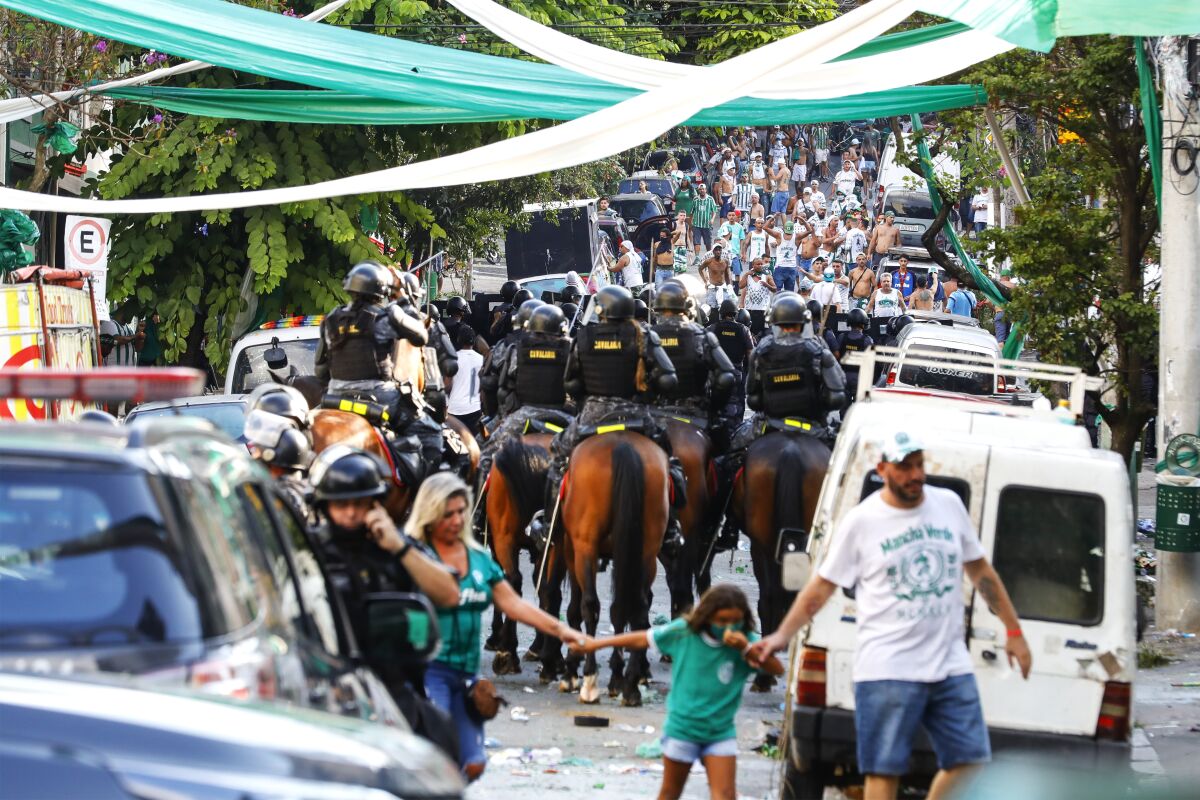 Riot police arrive to disperse dejected Palmeiras soccer club fans, who became rowdy after watching their team's defeat by Chelsea via a live broadcast, in Sao Paulo, Brazil, Saturday, Feb. 12, 2022. Chelsea went on to win the FIFA Club World Cup title match 2-1 that was played in Abu Dhabi. (AP Photo/Marcelo Chello)
