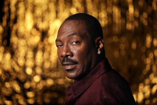 Eddie Murphy looks over his shoulder in front of a golden backdrop