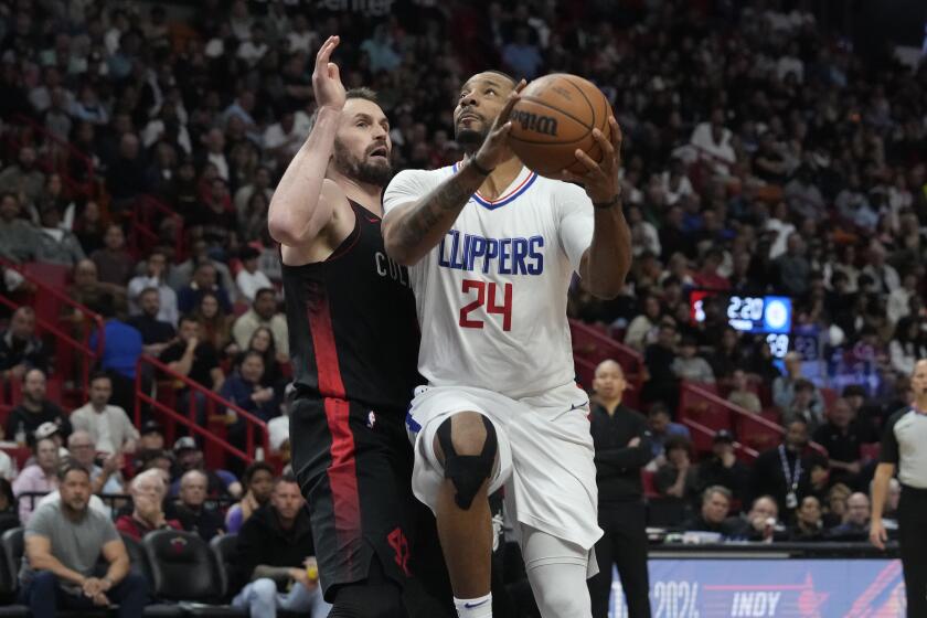 Los Angeles Clippers guard Norman Powell (24) drives to the basket as Miami Heat forward Kevin Love (42) defends during the first half of an NBA basketball game, Sunday, Feb. 4, 2024, in Miami. (AP Photo/Marta Lavandier)