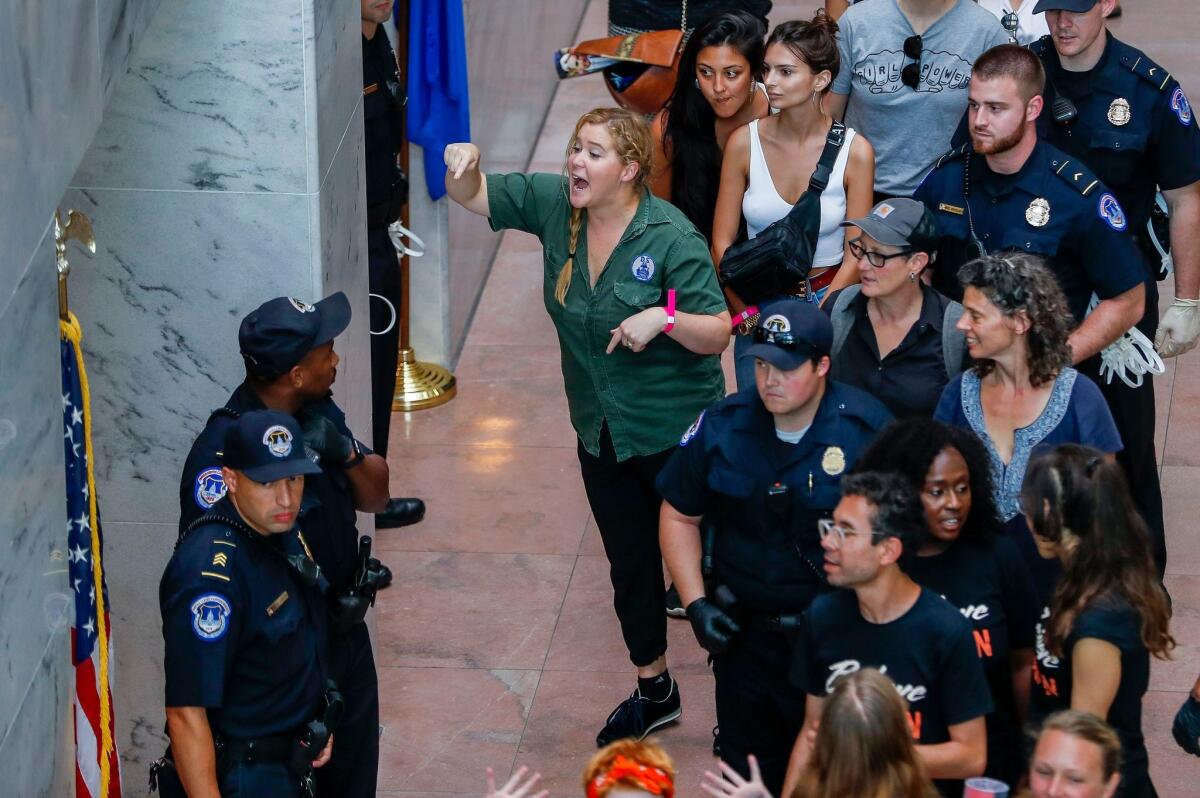 Comedian Amy Schumer gestures after being detained along with hundreds of other demonstrators at Hart Senate Office Building on Thursday.