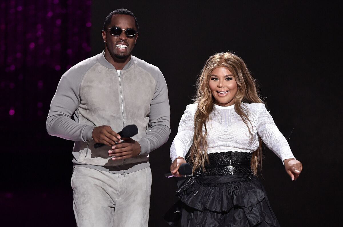Sean "Puff Daddy" Combs and Lil' Kim, shown performing together in July in New York, will start their Bad Boy Family Reunion Tour a week later than scheduled while Combs continues to recover from recent shoulder surgery.