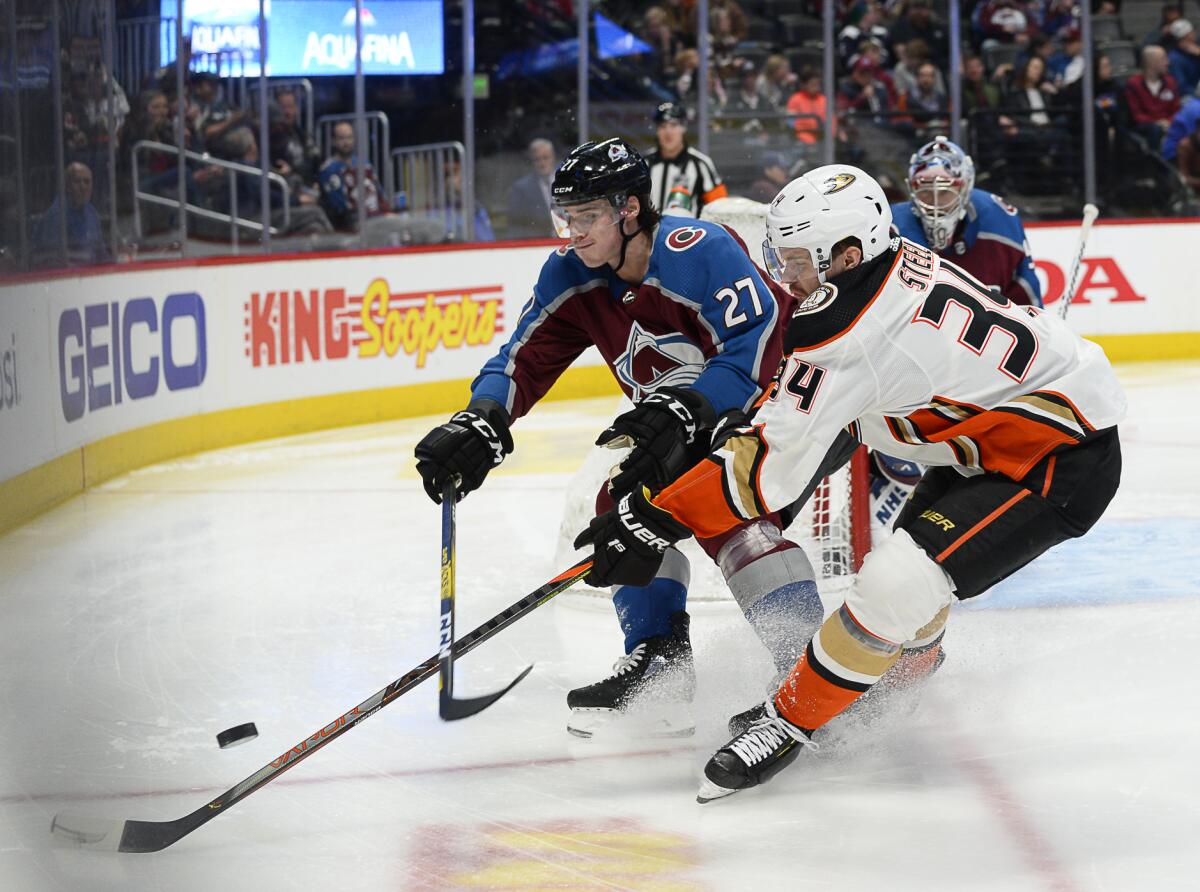 Avalanche defenseman Ryan Graves and Ducks center Sam Steel chase a puck into a corner during the second period of a game March 4 at the Pepsi Center.