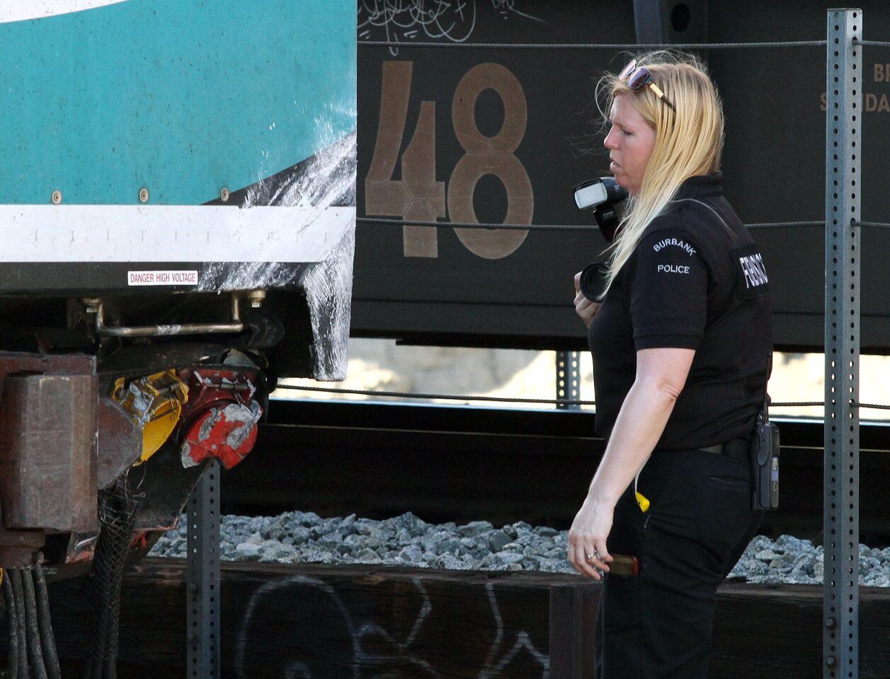 A forensics officer with the Burbank Police Department looks at the damage to the front of a Metrolink train after colliding with a motorist at the intersection of San Fernando and Buena Vista in Burbank on Monday, September 2, 2014. There was one driver taken to the hospital in critical condition, and six were injured on the train.