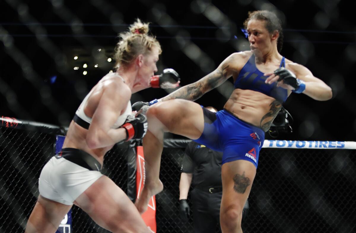 Holly Holm, left, and Germaine de Randamie exchange blows during their featherweight title fight at Barclays Center in New York on Saturday.