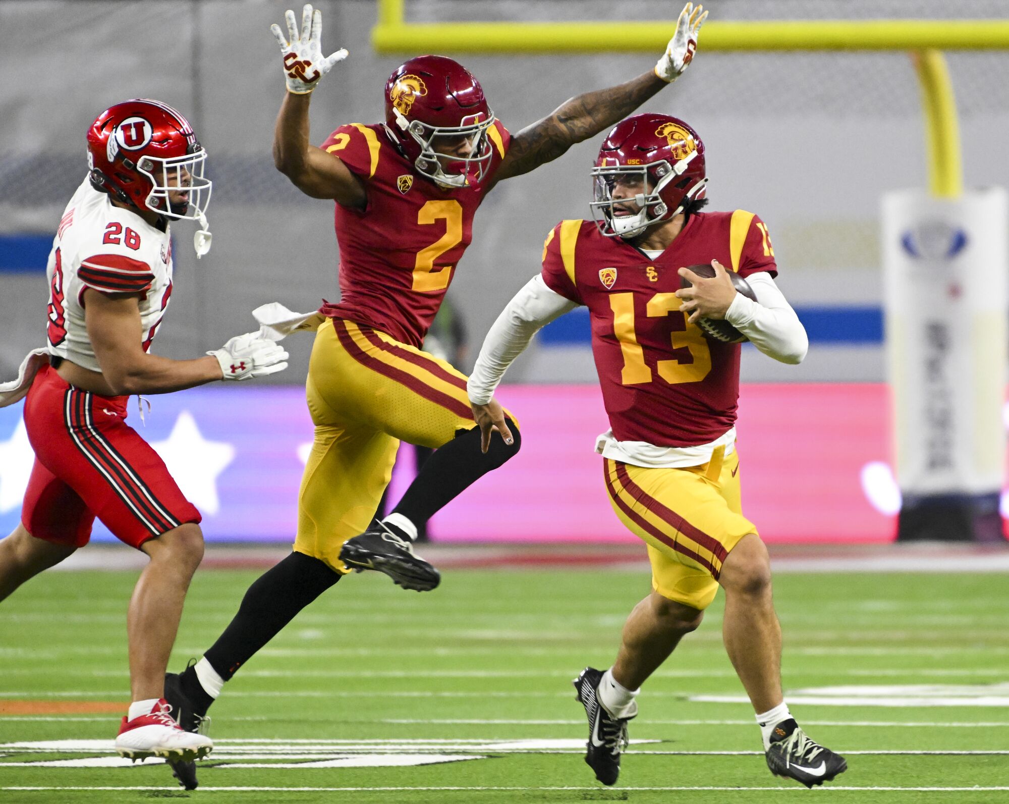 USC quarterback Caleb Williams runs with the football away from Utah safety Sione Vaki