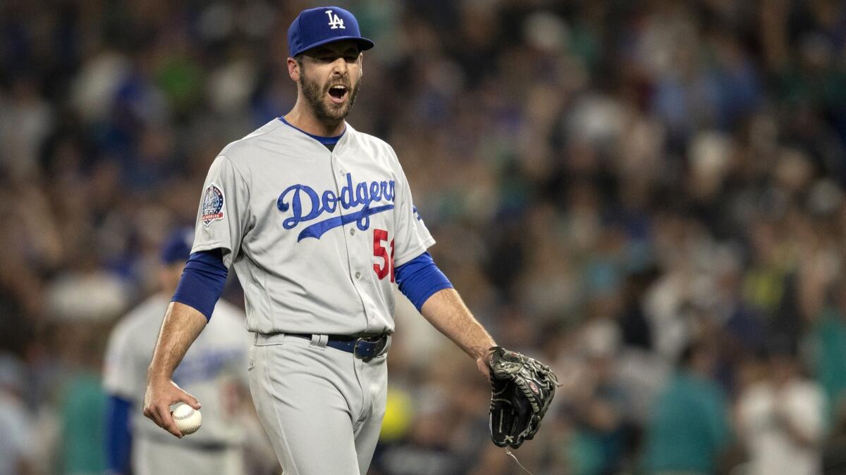 Dodgers relief pitcher Dylan Floro reacts after being called for balk that allowed the Seattle Mariners' Cameron Maybin to score from third base in the 10th inning.