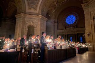 Hundreds of people light candles at the beginning of the Easter Vigil Mass at the Cathedral of St. Paul in St. Paul, Minn.