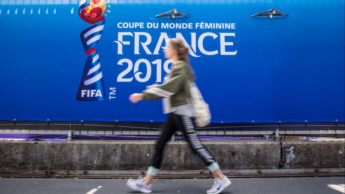 A woman walks past the Parc des Princes stadium on the eve of the opening match of the FIFA Women's World Cup 2019 in Paris.