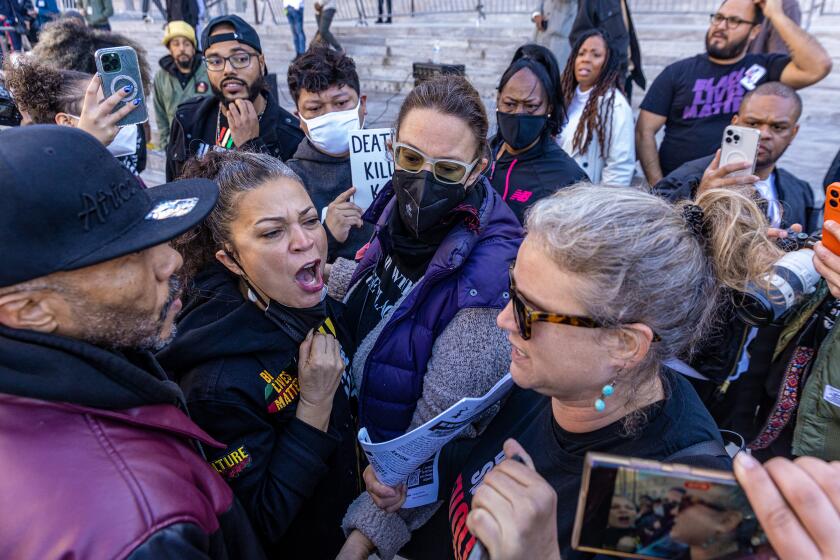 Los Angeles , CA - January 17:Black Lives Matter co-founder Melina Abdullah, second from left, and Lucha Bright from Revolution Club Los Angeles, in an heated argument after press conference held calling for the removal of the Los Angeles Police Department from minor traffic accidents, as well as restrictions on the police use of tasers, on the steps of City Hall on Tuesday, Jan. 17, 2023 in Los Angeles , CA. (Irfan Khan / Los Angeles Times)