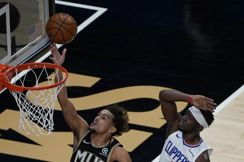 Atlanta Hawks guard Trae Young (11) goes up for a basket as Los Angeles Clippers guard Reggie Jackson (1) defends in the first half of an NBA basketball game Tuesday, Jan. 26, 2021, in Atlanta. (AP Photo/John Bazemore)