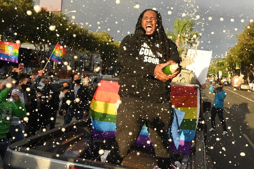 WEST HOLLYWOOD, CALIFORNIA NOVEMBER 7, 2020-A Biden supporter that goes by thhe name "Poudii" sprays champagne along Santa Monica Blvd. in West Hollywood Saturday after Joe Biden won the Presidency. (Wally Skalij/Los Angeles Times)