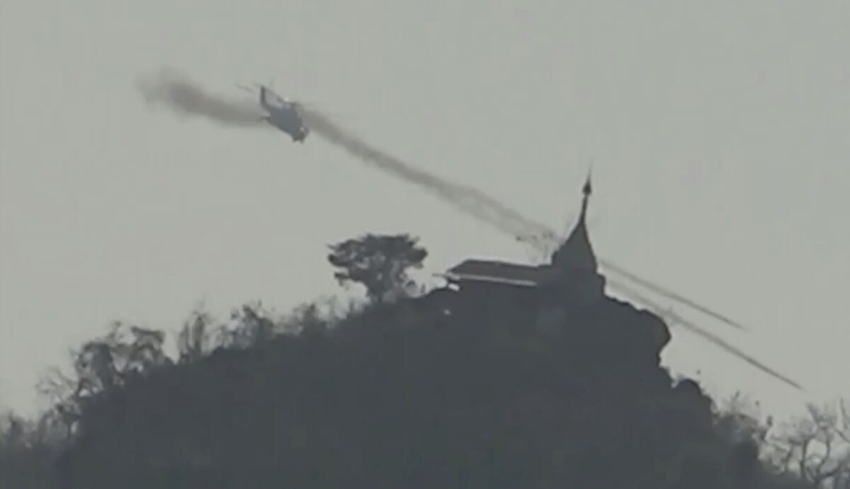 In this image taken from video provided by Free Burma Rangers, a Myanmar military helicopter fires rockets west of Loikaw in Kayah State, Myanmar on Feb. 21, 2022. While Russia’s war in Ukraine dominates global attention, Myanmar’s military is targeting civilians in air and ground attacks on a scale unmatched in the country since World War II, according to a longtime relief worker who spent almost three months in a combat zone in the Southeast Asian nation. (Free Burma Rangers via AP)